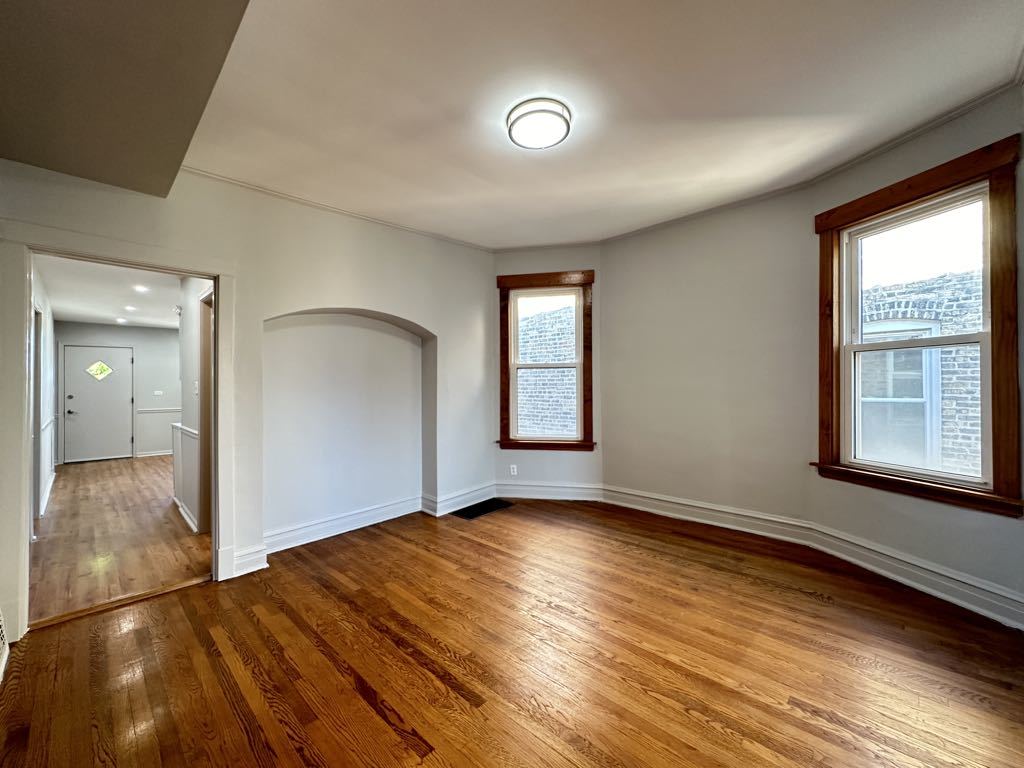 4020 West Cornelia Avenue, Unit 2 Chicago, IL 60641 - Photo 7 of 20 a view of an empty room with wooden floor and a window