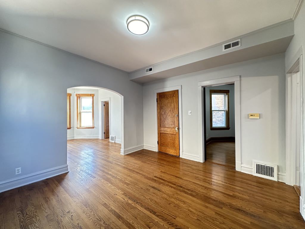 4020 West Cornelia Avenue, Unit 2 Chicago, IL 60641 - Photo 8 of 20 an empty room with wooden floor and windows