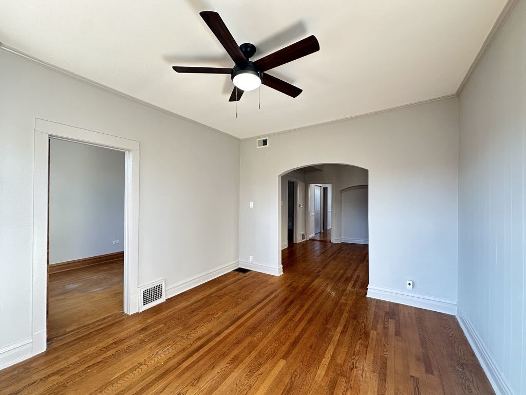 4020 West Cornelia Avenue, Unit 2 Chicago, IL 60641 - Photo 10 of 20 a view of empty room with wooden floor and fan