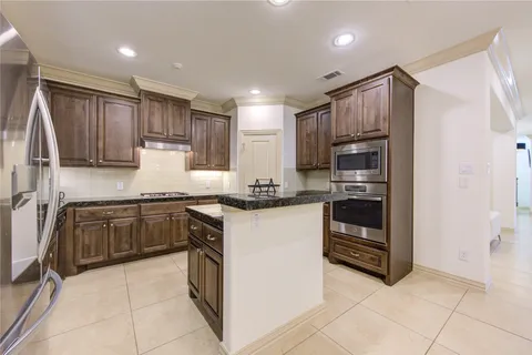 a kitchen with granite countertop stainless steel appliances and wooden cabinets