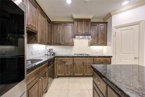 a kitchen with stainless steel appliances granite countertop a stove and cabinets