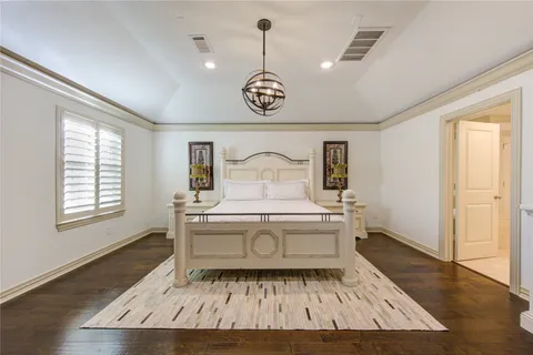 a spacious bedroom with a bed and a flat screen tv