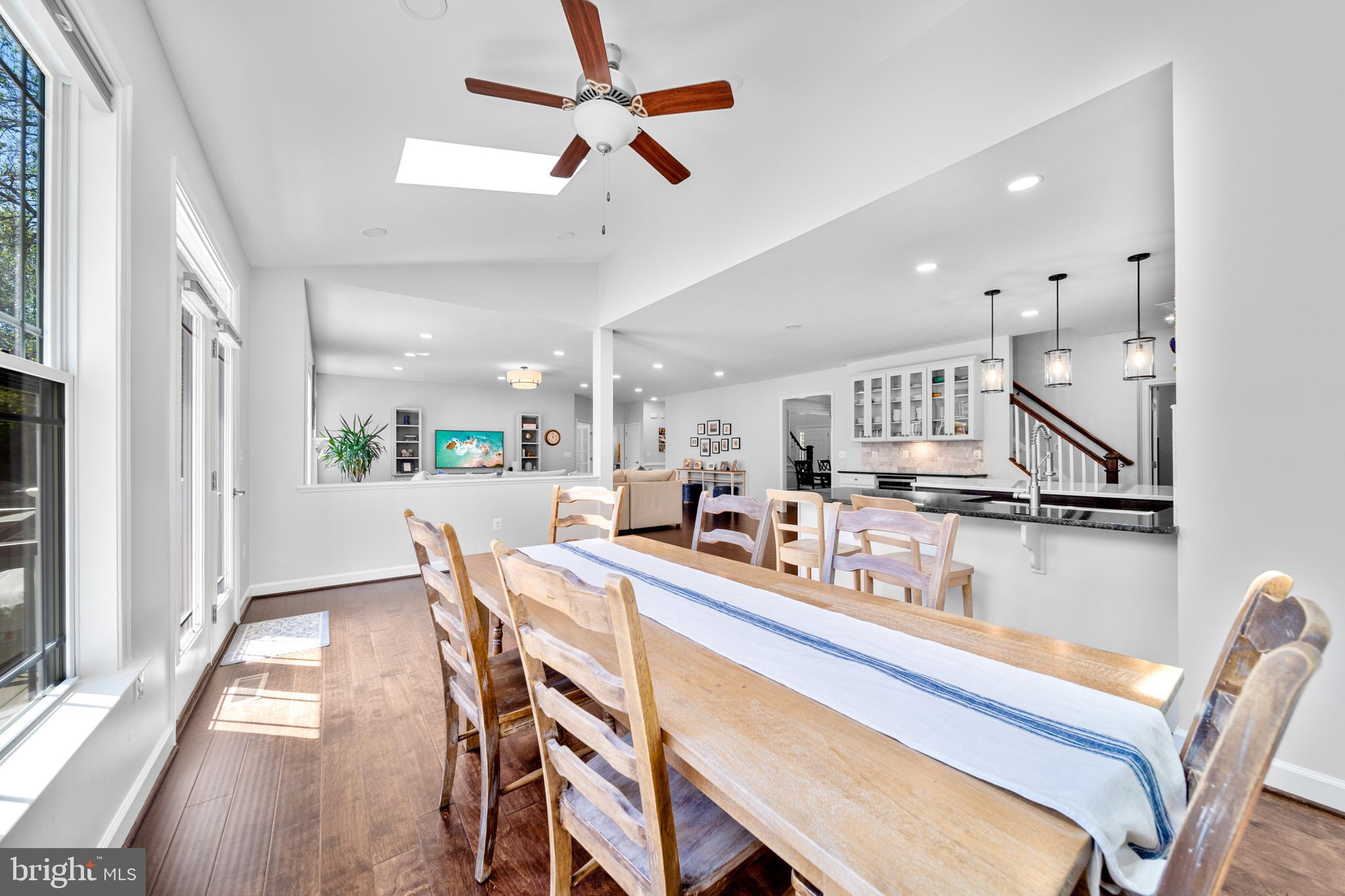 1639 Macon Street McLean, VA 22101 - Photo 23 of 86 a kitchen with stainless steel appliances kitchen island granite countertop a table chairs in it and wooden floors