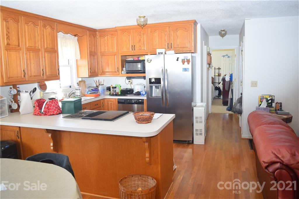 3189 Short Road Hickory, NC 28602 - Photo 22 of 24 a kitchen with stainless steel appliances granite countertop a refrigerator a sink dishwasher and a dining table with wooden floor