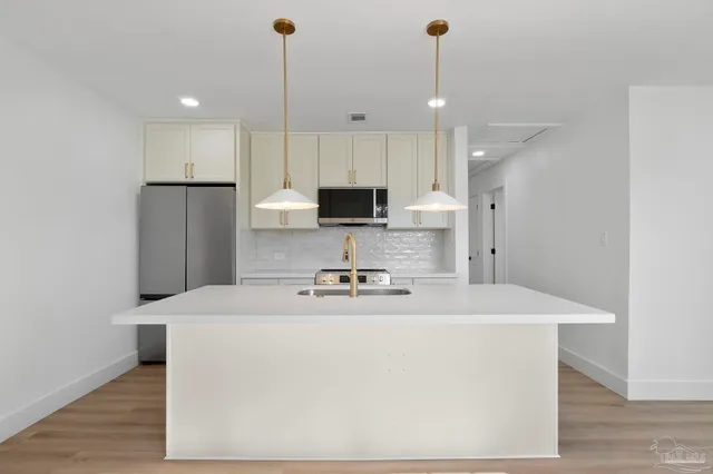 a kitchen with a sink a stove a refrigerator and a window