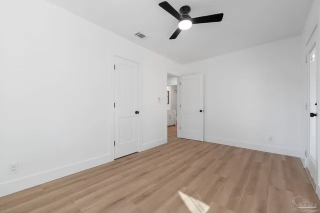 an empty room with windows and fireplace