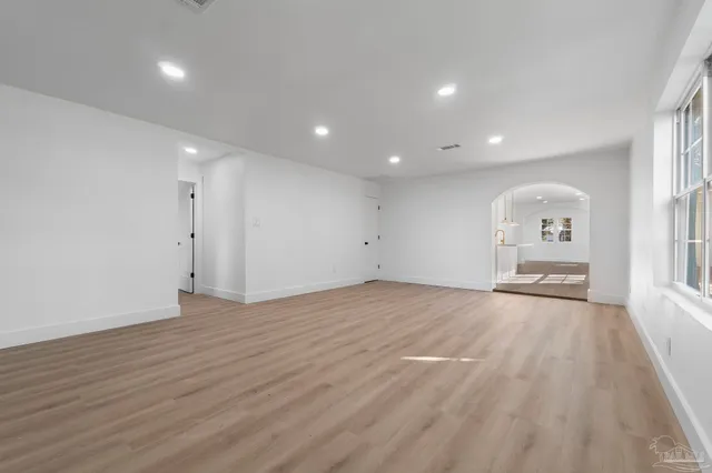 a view of an empty room with wooden floor and closet