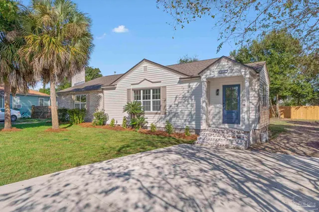 a front view of a house with a garden and yard