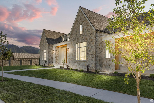 478 South Maple Lakes Drive Mapleton, UT 84664 - Photo 49 of 51 Stone facade residence featuring a prominent gabled roofline, multiple large windows with grid patterns, and a covered entryway with wood-toned accents