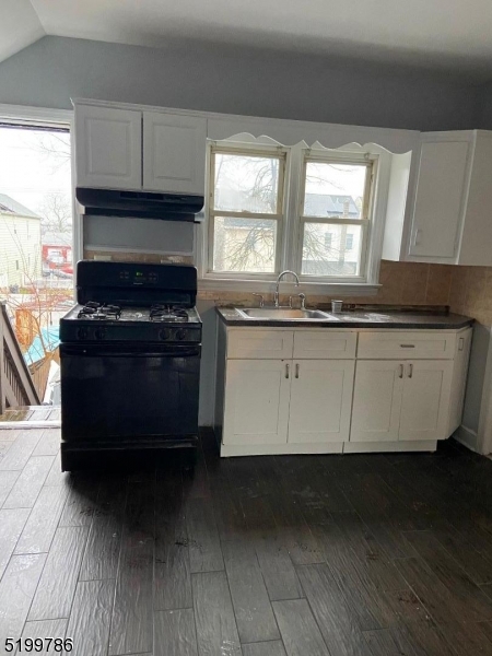33 Ryerson Avenue, Unit 2 Paterson, NJ 07502 - Photo 4 of 6 a kitchen with stainless steel appliances granite countertop a stove a sink and a microwave