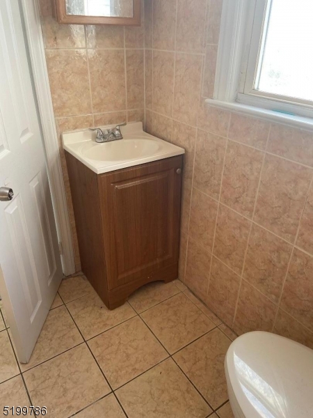 33 Ryerson Avenue, Unit 2 Paterson, NJ 07502 - Photo 6 of 6 a bathroom with a sink a toilet and a mirror