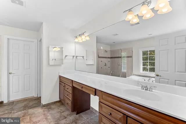 a spacious bathroom with a granite countertop sink a light fixture and a mirror