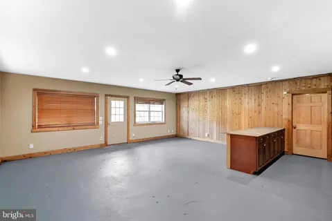an empty room with windows and ceiling fan