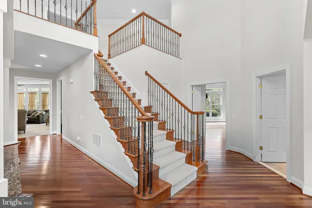 a view of staircase with lots of frames on wall and wooden floor