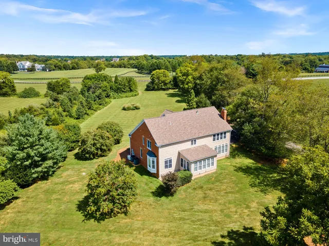 a aerial view of a house with a yard and lake view