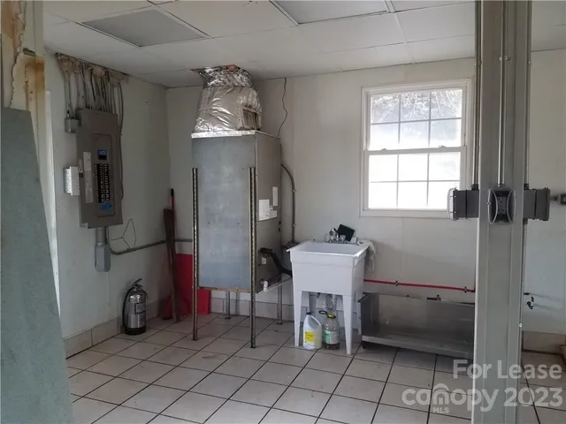 a backyard of a house with large trees and wooden fence