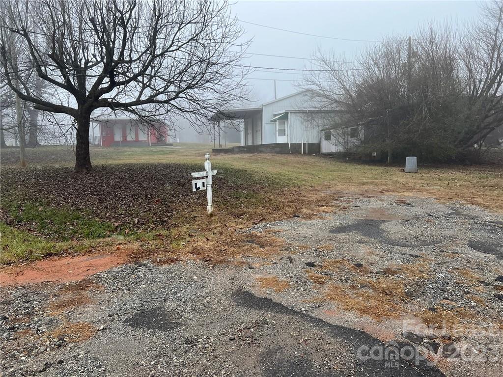 286 Chimney Rock Road Rutherfordton, NC 28139 - Photo 29 of 31 a backyard of a house with large trees and wooden fence