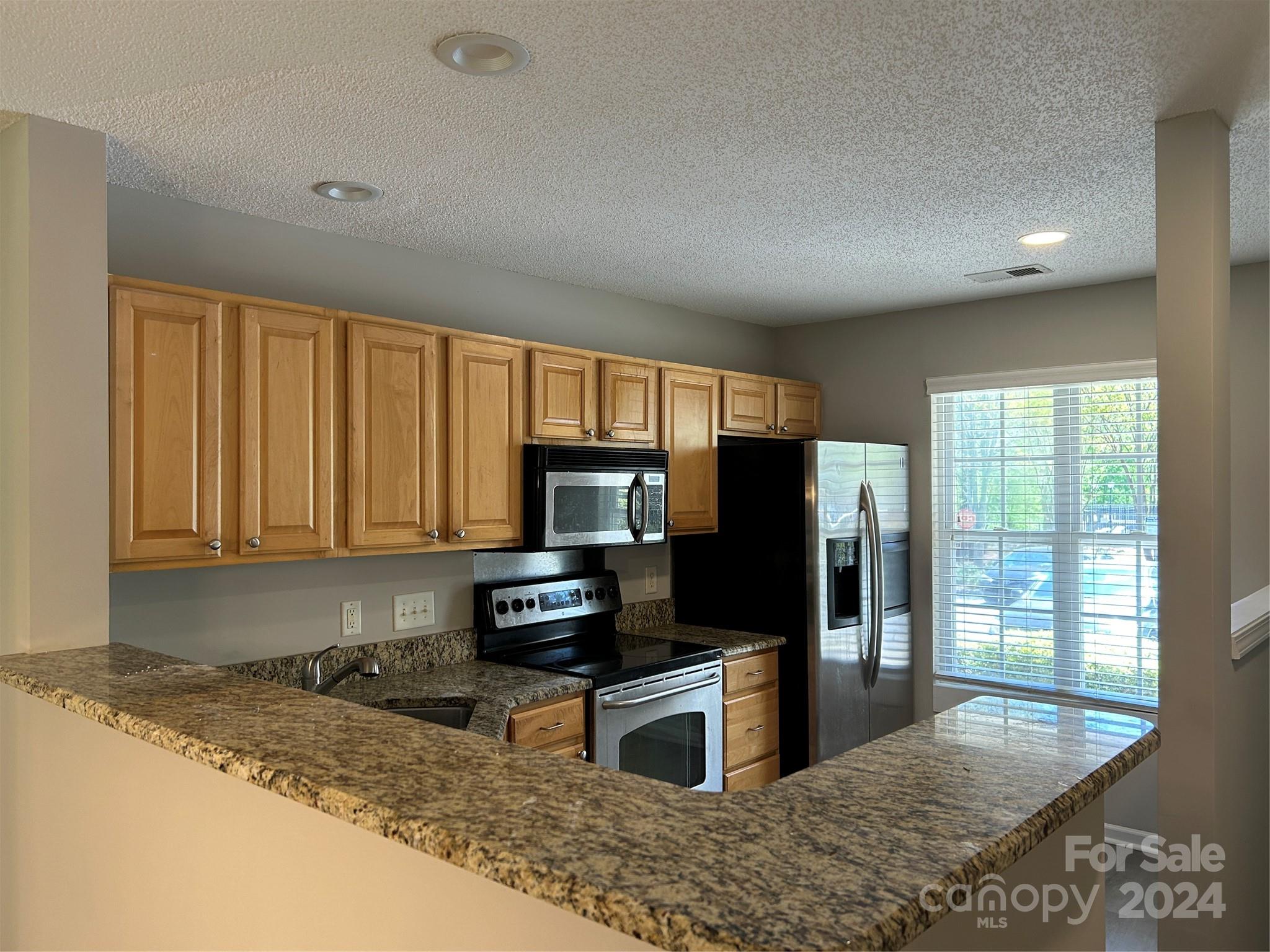 10511 Prairie Ridge Lane Charlotte, NC 28213 - Photo 2 of 17 a kitchen with granite countertop a refrigerator and a sink