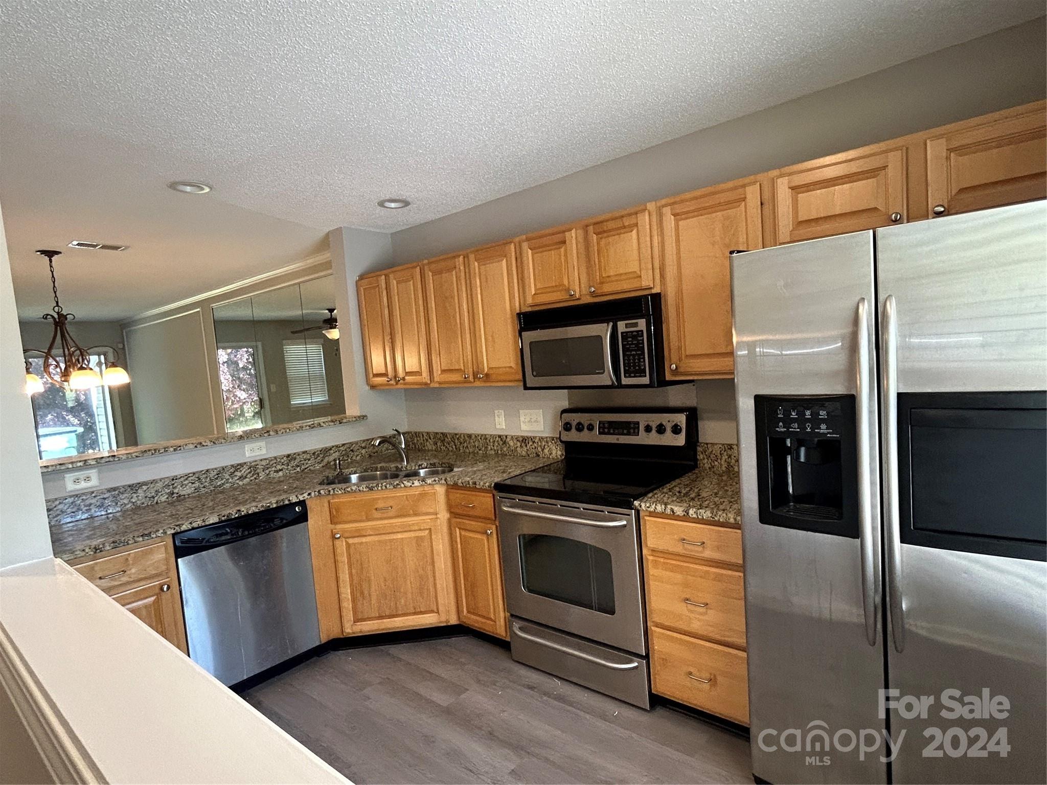 10511 Prairie Ridge Lane Charlotte, NC 28213 - Photo 3 of 17 a kitchen with stainless steel appliances granite countertop a stove a sink and a microwave