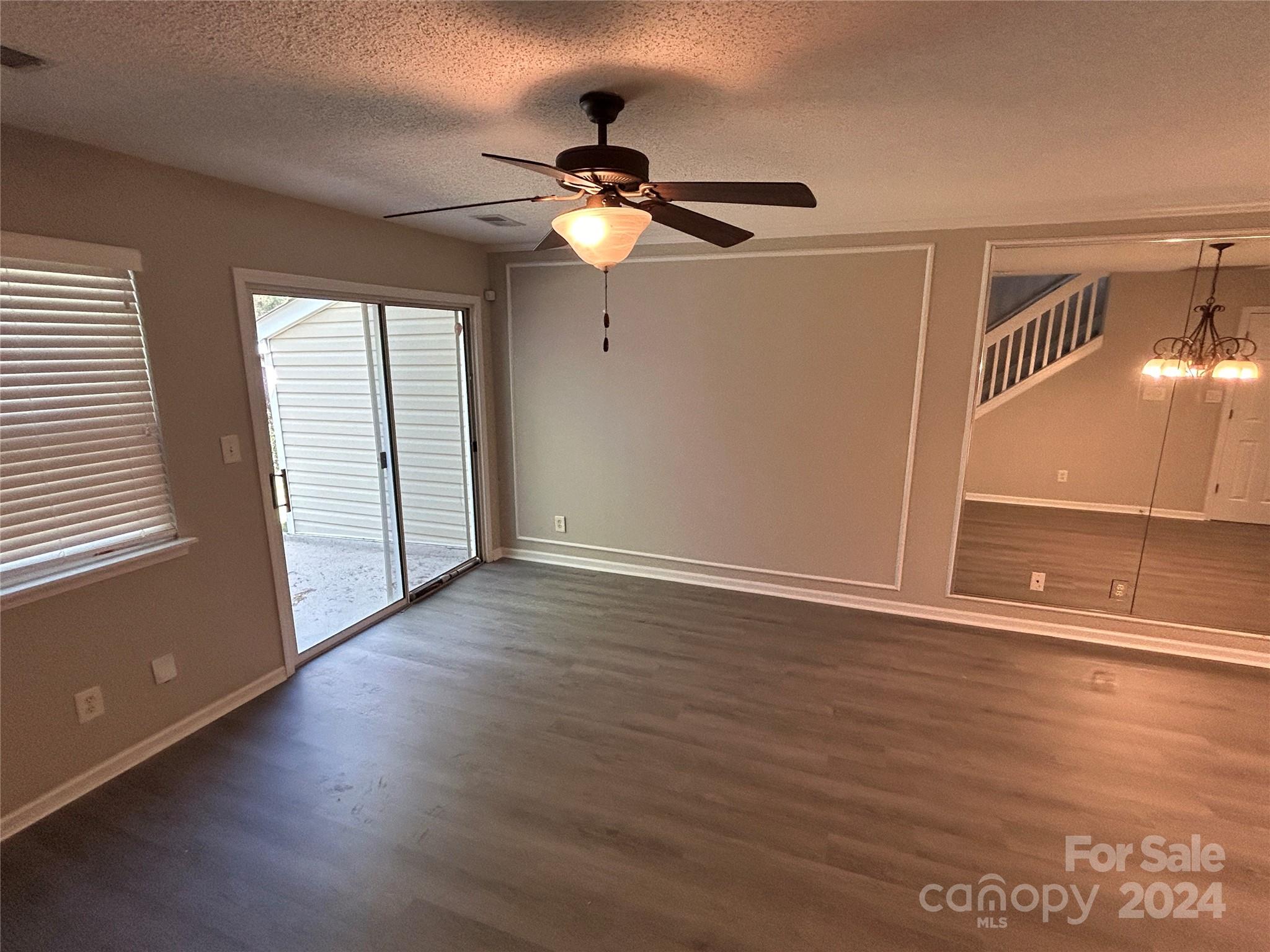 10511 Prairie Ridge Lane Charlotte, NC 28213 - Photo 6 of 17 a view of a livingroom with wooden floor a ceiling fan and window