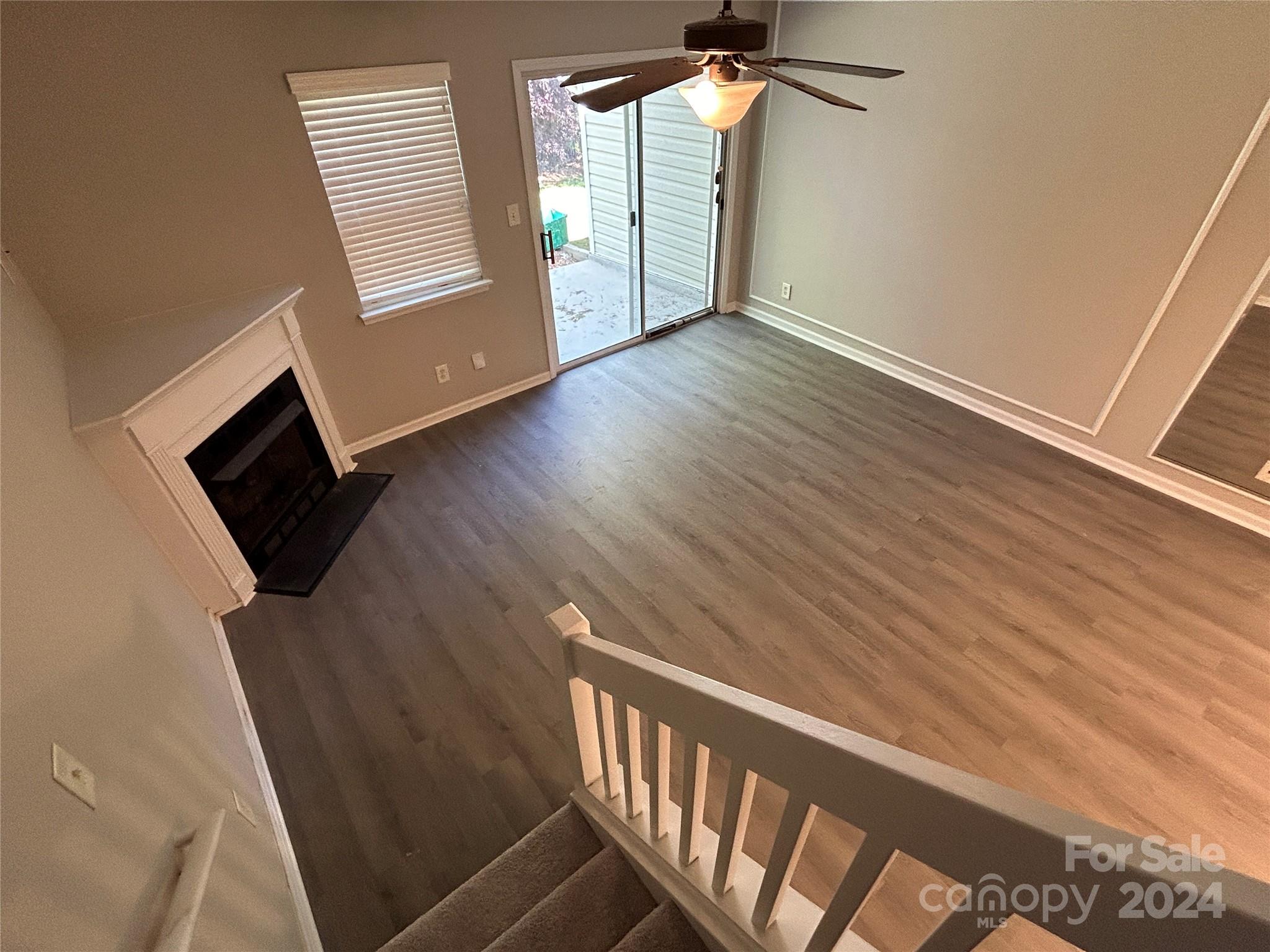 10511 Prairie Ridge Lane Charlotte, NC 28213 - Photo 8 of 17 an empty room with wooden floor fan and windows