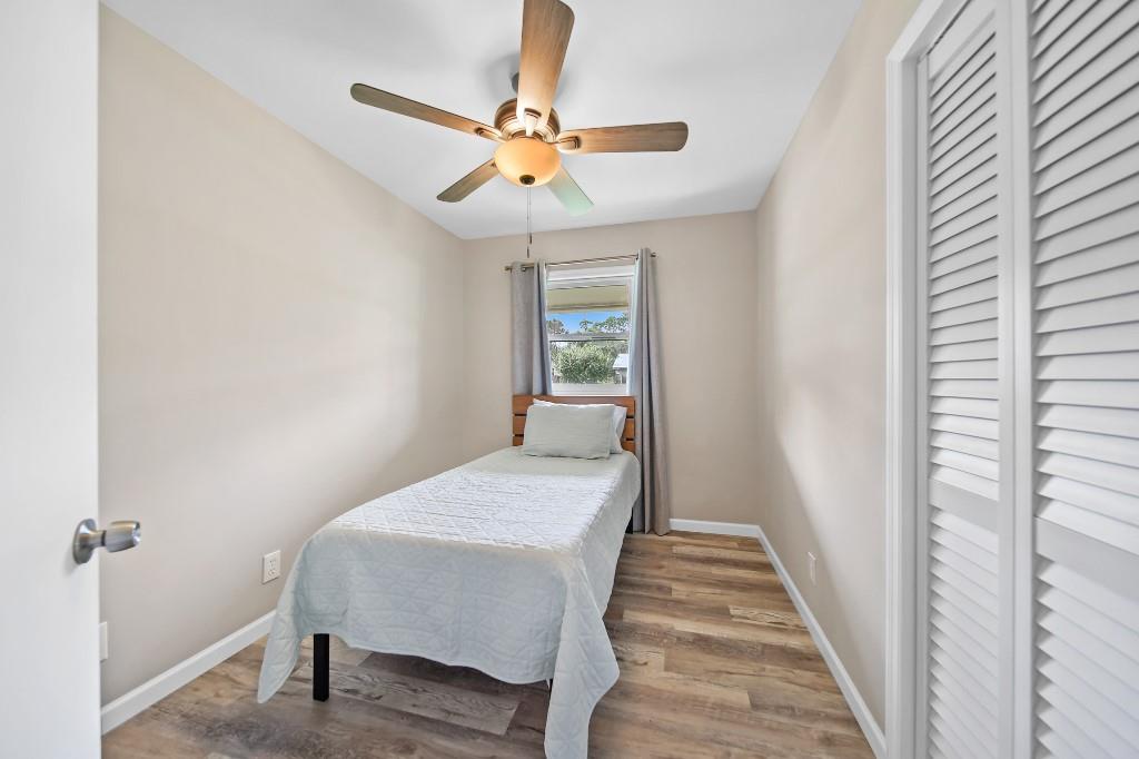 6275 Southeast Thomas Drive Stuart, FL 34997 - Photo 16 of 27 a bedroom with a bed and a chandelier