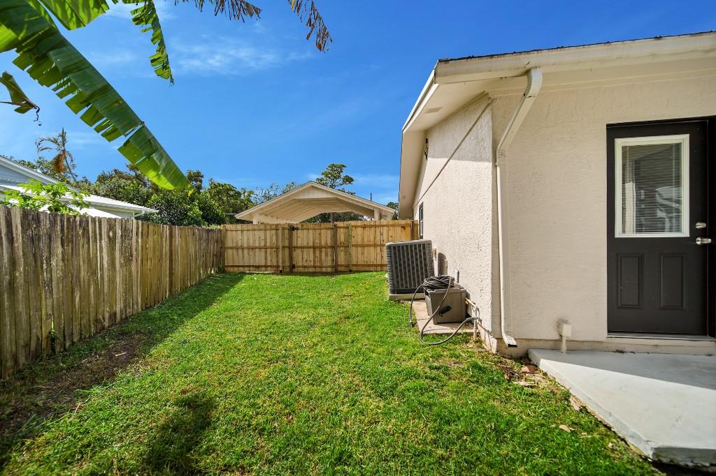 6275 Southeast Thomas Drive Stuart, FL 34997 - Photo 24 of 27 a view of backyard with wooden fence and large trees