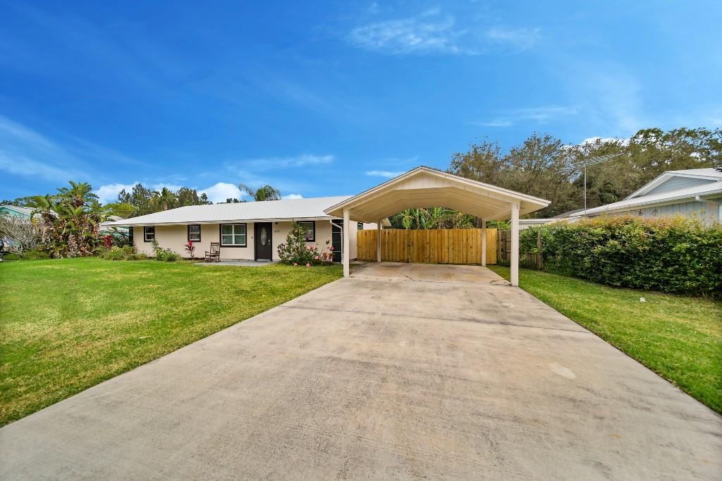6275 Southeast Thomas Drive Stuart, FL 34997 - Photo 4 of 27 a front view of a house with yard and green space