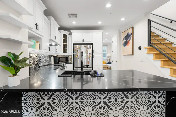 a kitchen with stainless steel appliances granite countertop a refrigerator sink and cabinets
