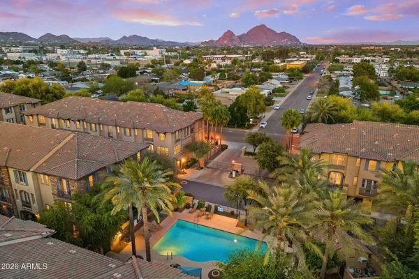 an aerial view of residential houses with outdoor space and trees