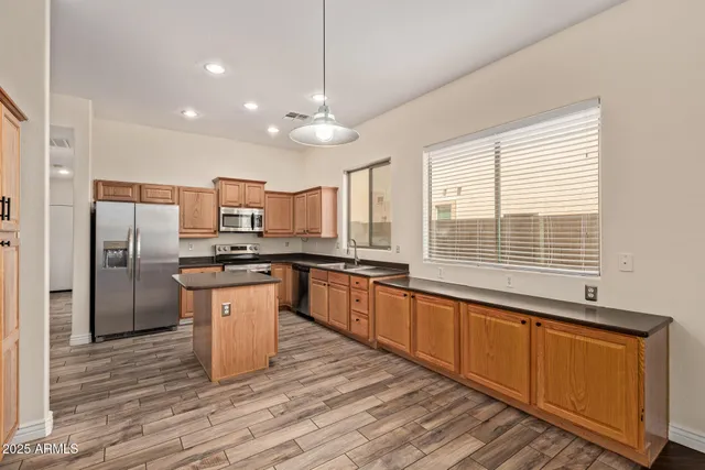 a kitchen with stainless steel appliances granite countertop a sink a stove and refrigerator