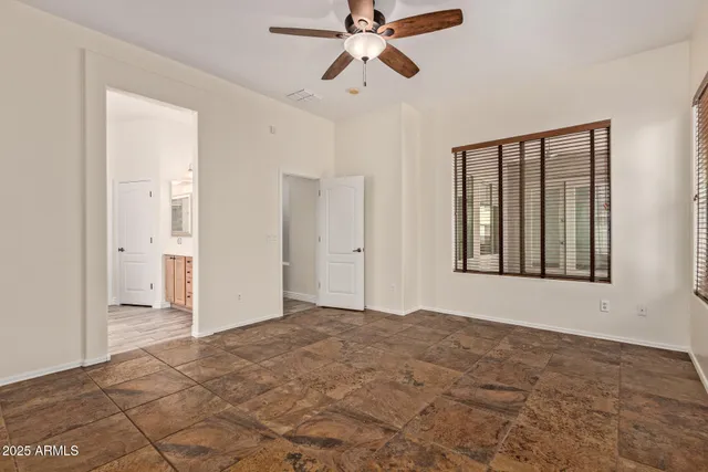 a view of empty room with window and ceiling fan