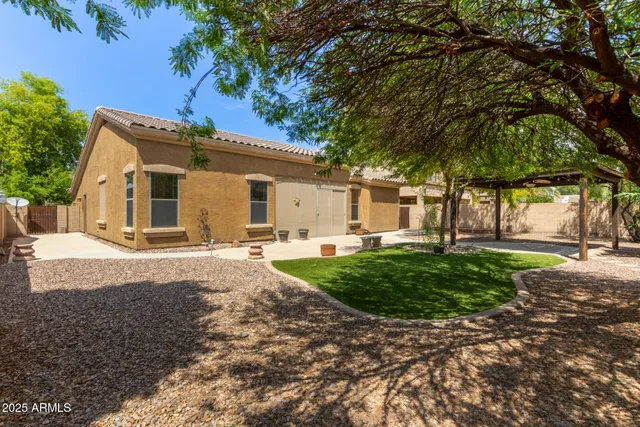 a view of a house with backyard and a tree