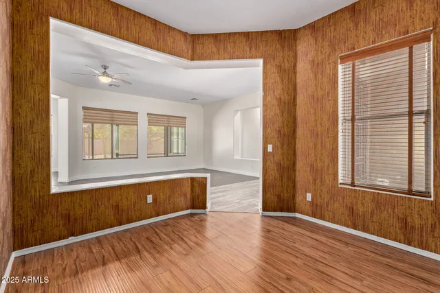 a view of an empty room with a window and wooden floor
