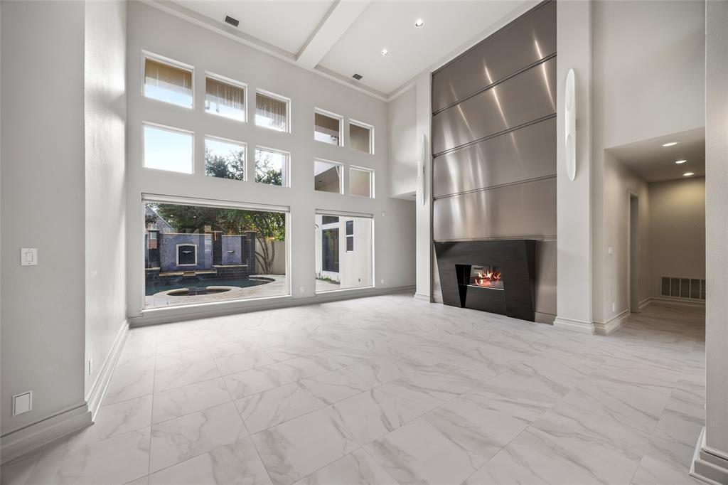 5608 Stone Cliff Court Dallas, TX 75287 - Photo 3 of 35 a view of an empty room with a fireplace and a window