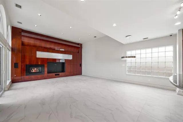 a view of an empty room with a fireplace and a window