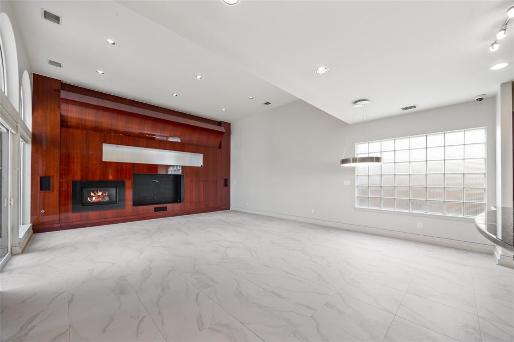 5608 Stone Cliff Court Dallas, TX 75287 - Photo 8 of 35 a view of an empty room with a fireplace and a window
