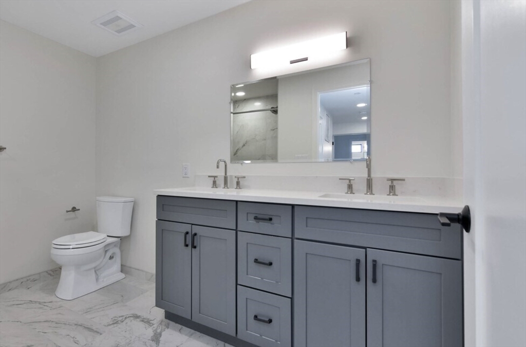 215 Canal Street, Unit 1 Lawrence, MA 01840 - Photo 5 of 6 a bathroom with a toilet sink and mirror