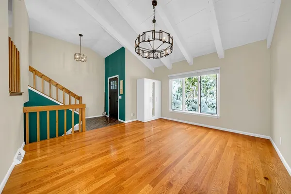 a view of an empty room with wooden floor