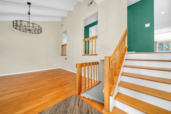 a view of staircase with wooden floor and fan