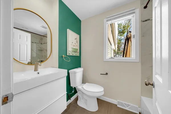 a bathroom with a toilet sink and mirror