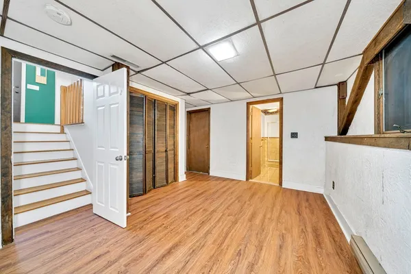 a view of a hallway with wooden floor and entryway