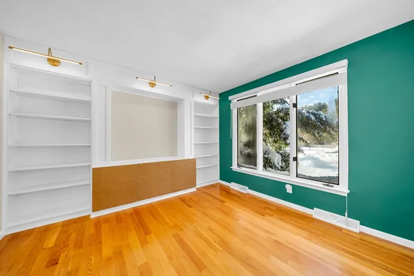 a view of a room with wooden floor and windows