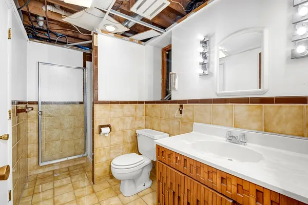 a bathroom with a sink a toilet and shower
