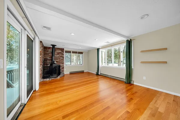 a view of an empty room with furniture and windows