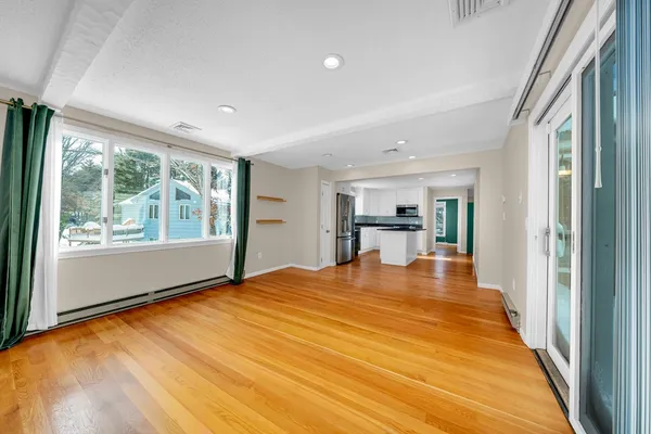 a big room with wooden floor and a window