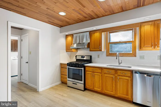 a kitchen with wooden floors and stainless steel appliances