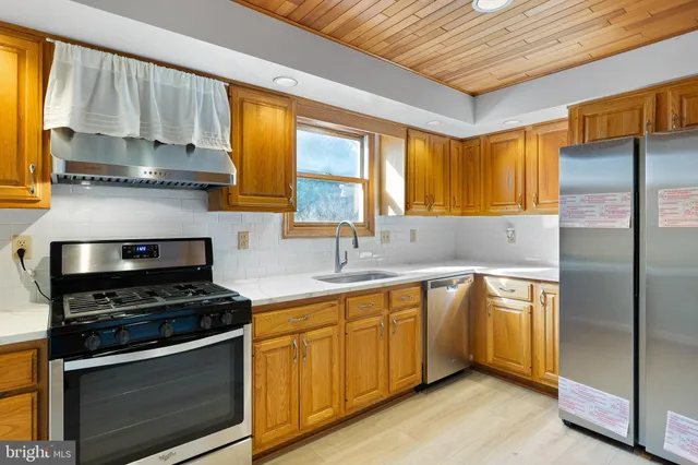 a kitchen with stainless steel appliances a stove a sink and a refrigerator