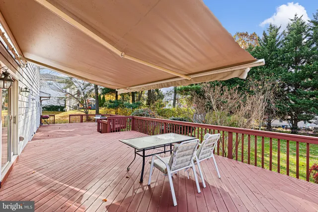 a view of a patio with table and chairs under an umbrella with wooden floor