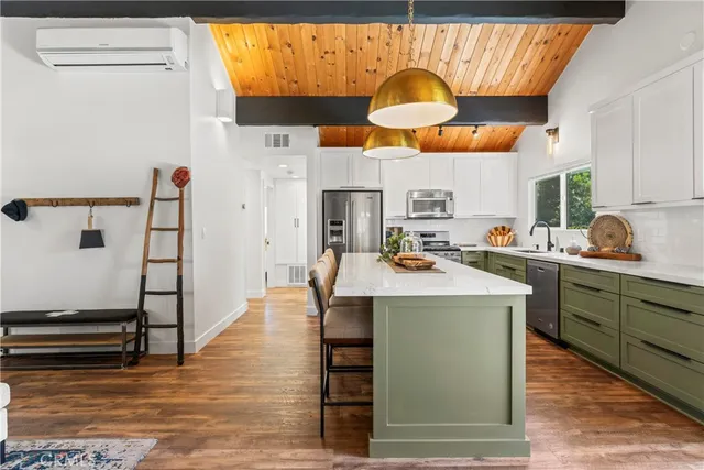 a kitchen with stainless steel appliances granite countertop a sink a stove counter space and cabinets